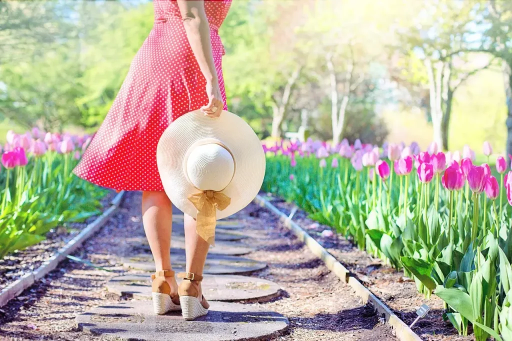 Girl-walking-on-a-path-with-hat-in-her-hand